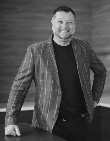 Black-and-white professional portrait of Marek Rodkiewicz, Design & Build Consultant at Trendsetter Homes.