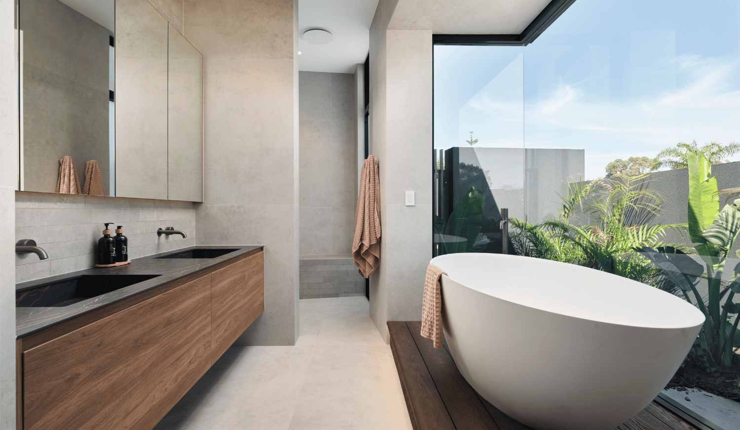 Luxury bathroom in a Marmion custom home featuring a freestanding bath, natural stone finishes and large windows.