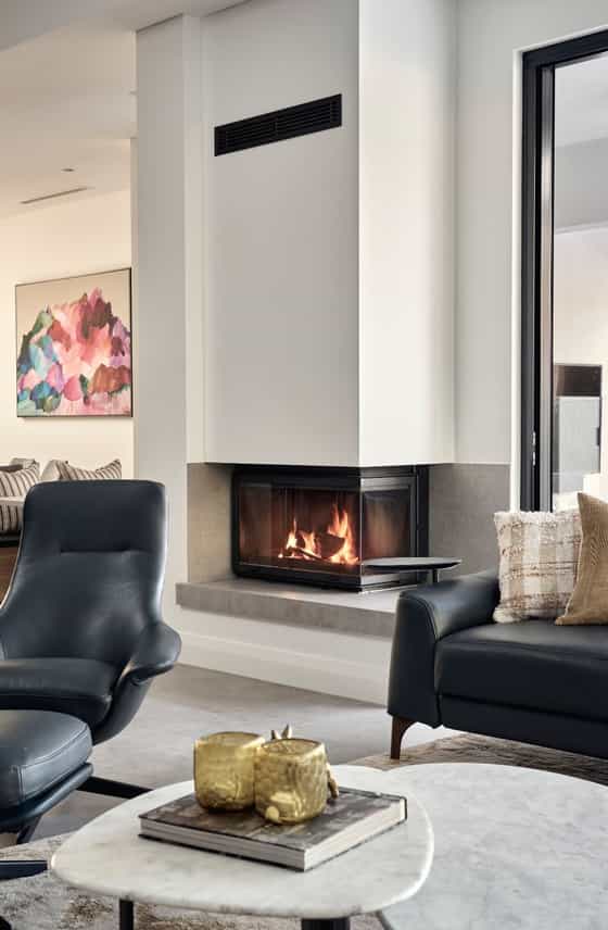 Custom home living room featuring a built-in fireplace, contemporary artwork and modern interior finishes.