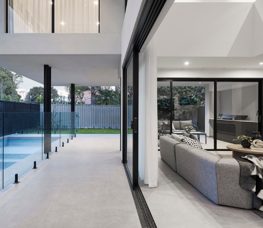 Outdoor swimming pool and alfresco area featuring expansive glazing and landscaped gardens at a custom home in Ardross.