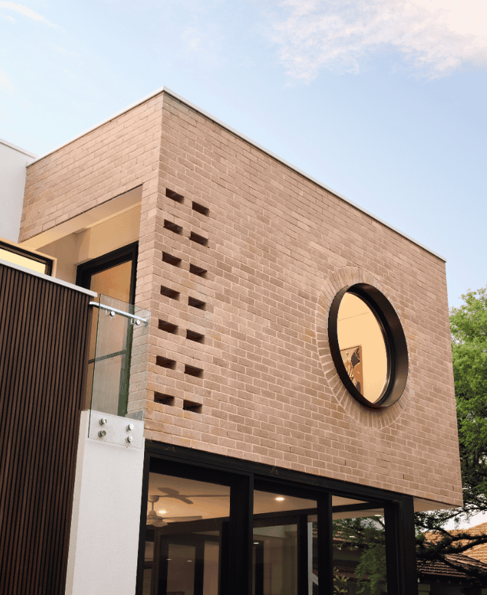 Architectural detail of a circular window and feature brickwork at a contemporary Nedlands custom home.