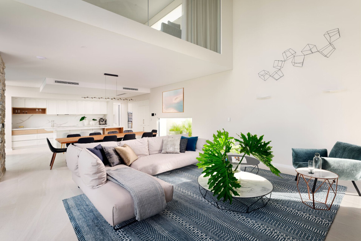 Double-height open-plan living area at The Grove in Wembley featuring large windows, contemporary furnishings and natural light.