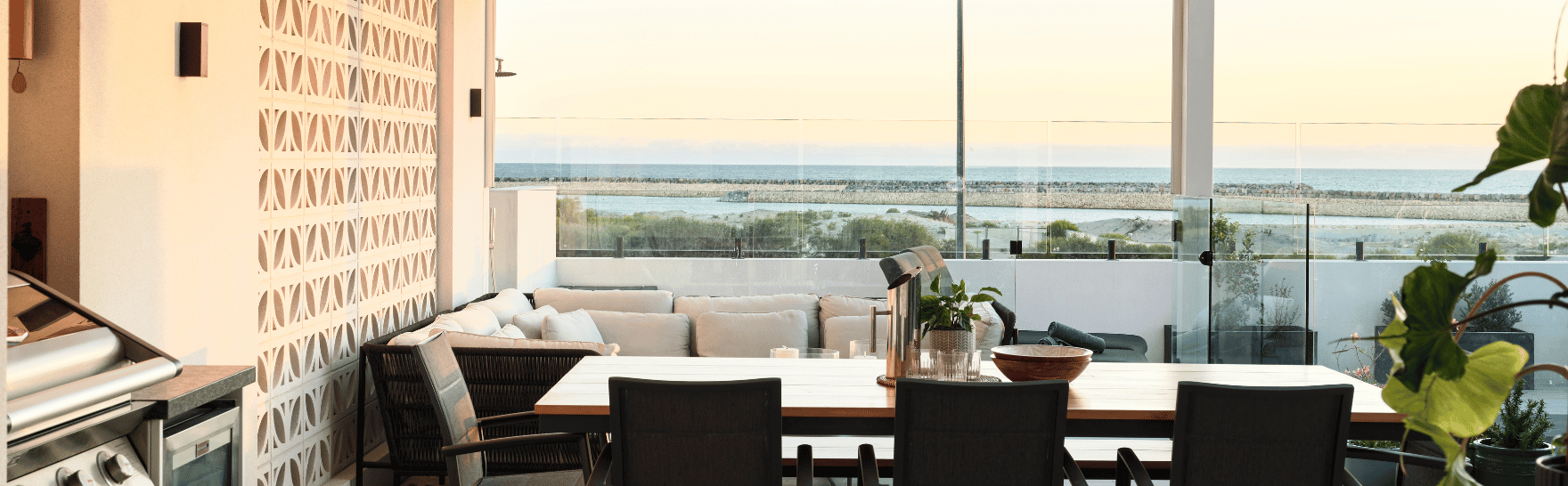 Coastal alfresco entertaining area featuring outdoor seating, timber ceiling detailing and expansive ocean views.