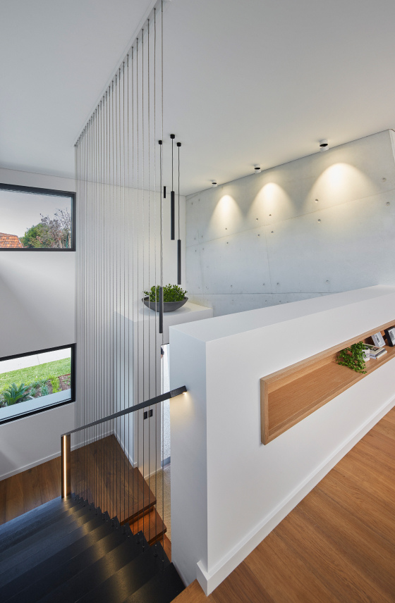Custom home interior featuring a double-height ceiling, pendant lighting and expansive glazing.