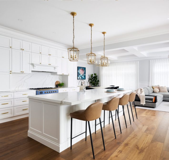 A luxury white and gold kitchen with white island countertop inside a luxury custom built home