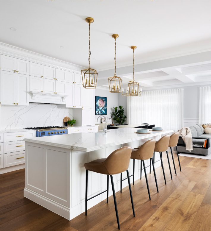 A luxury white and gold kitchen with white island countertop inside a luxury custom built home